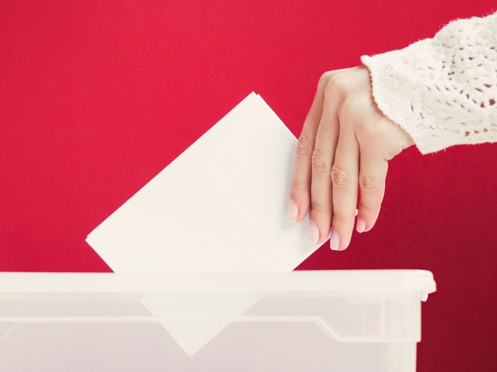 woman-putting-card-mock-up-in-box-for-election